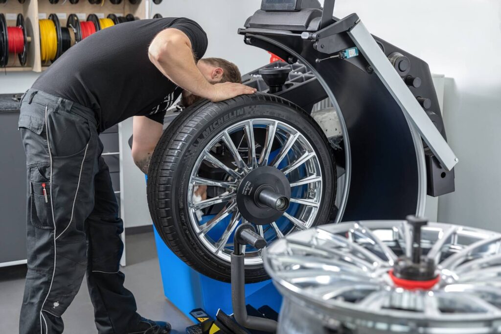 Reifenmontage in Illnau-Effretikon – Techniker montiert Michelin Reifen auf Alufelge bei SwissCarMarket